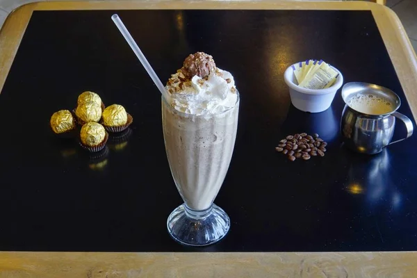 黒のテーブルの上にチョコレートミルクシェイクのガラスの高い角度のクローズアップショット — ストック写真
