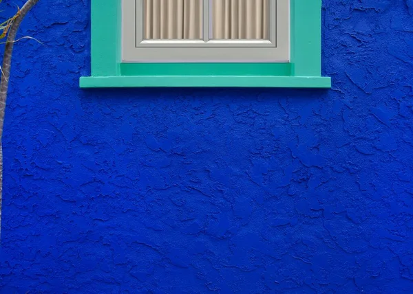 ネイビーブルーの塗装が施された美しい質感の壁に木製の青い窓 — ストック写真