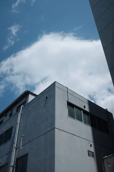 Ângulo Baixo Vertical Disparado Edifício Concreto Sob Nuvens Céu Azul — Fotografia de Stock