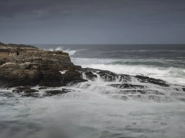 曇り空の下で岩の崖の上の海の波の息をのむような景色 — ストック写真