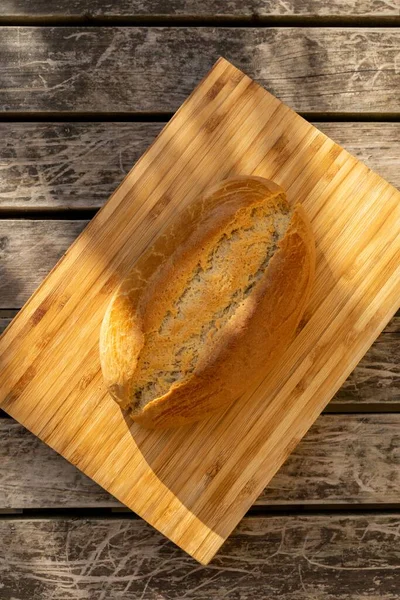 Ein Vertikaler Schuss Sauerteigbrot Auf Einem Hellen Holzschneidebrett Auf Einer — Stockfoto