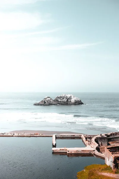 一张美丽海滩的垂直照片 中间有一个岩石岛 — 图库照片