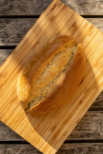 Ein Vertikaler Schuss Sauerteigbrot Auf Einem Hellen Holzschneidebrett Auf Einer — Stockfoto