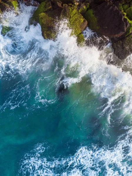 Μια Κάθετη Εναέρια Λήψη Κυματιστή Γαλάζιας Θάλασσας Πάνω Στα Βράχια — Φωτογραφία Αρχείου
