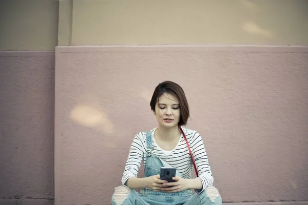 Une Jeune Femme Assise Sur Trottoir Textant Téléphone Sous Lumière — Photo
