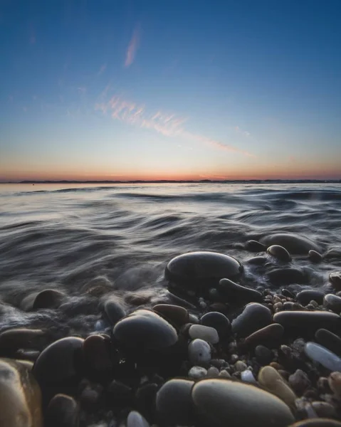 岩石海滩上美丽落日的垂直镜头 — 图库照片