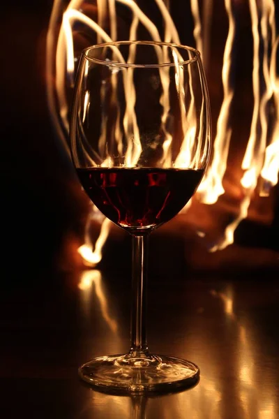 Eine Vertikale Selektive Fokusaufnahme Eines Weinglases Mit Rotwein Mit Lichtern — Stockfoto