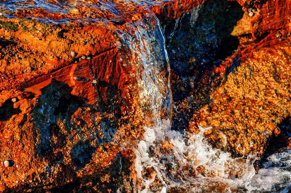 海の岩の層を流れる水 — ストック写真