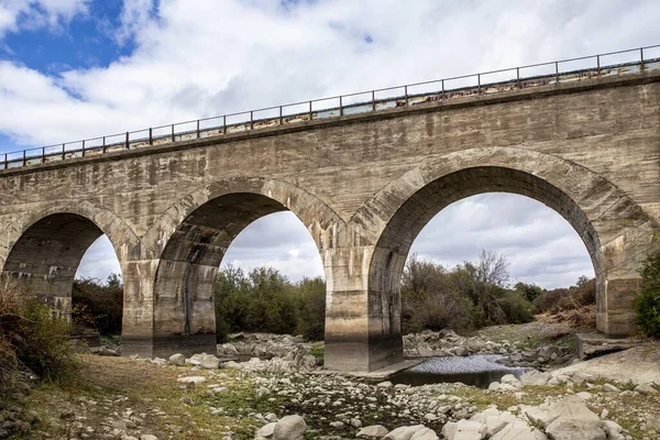 Kemerleri Bulutlu Gökyüzü Olan Taş Bir Köprü — Stok fotoğraf