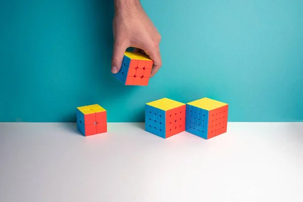 Gros Plan Une Personne Mettant Différentes Tailles Rubik Cube Sur — Photo