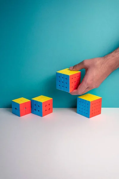 Plan Vertical Une Personne Mettant Différentes Tailles Rubik Cube Sur — Photo