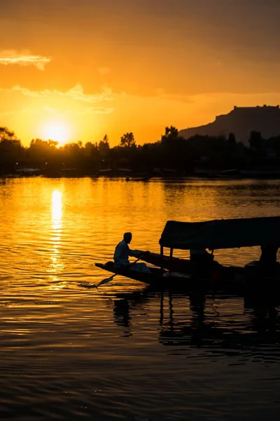 在美丽的日落背景上 一张小舟和一些人的轮廓的令人叹为观止的照片 — 图库照片