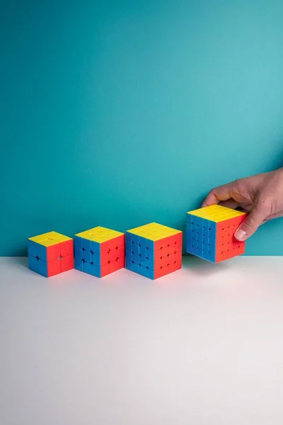 Una Toma Vertical Una Persona Poniendo Diferentes Tamaños Cubo Rubik —  Fotos de Stock