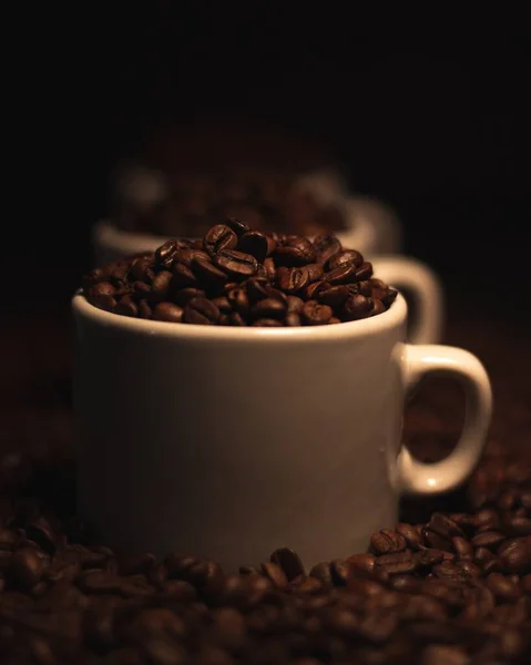 Zbliżenie Ujęcie Białych Kubków Kawy Wypełnionych Paloną Ziarenką Kawy — Zdjęcie stockowe