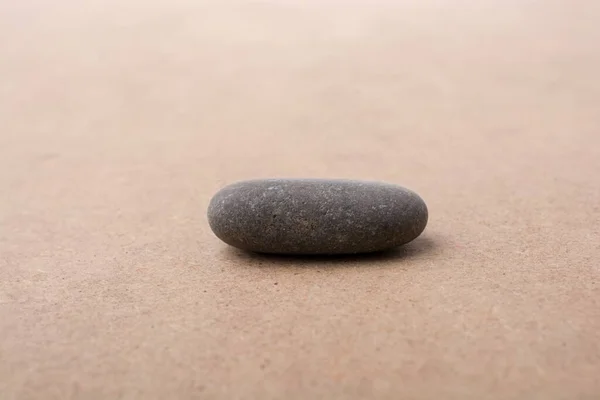 Nahaufnahme Eines Ovalen Steins Auf Beiger Oberfläche — Stockfoto