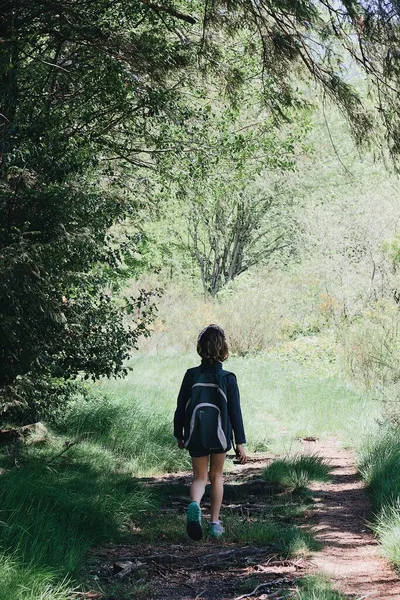 Μια Κάθετη Φωτογραφία Μιας Τουρίστριας Περπατά Ένα Δρόμο Καλυμμένο Γρασίδι — Φωτογραφία Αρχείου