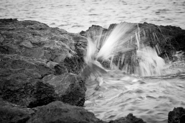 Strzał Fal Morskich Skali Szarości Rozpryskujący Się Pobliżu Formacji Skalnych — Zdjęcie stockowe