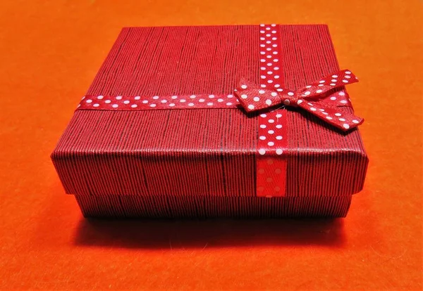 Tiro Close Uma Caixa Presente Vermelha Envolto Uma Fita Pontilhada — Fotografia de Stock
