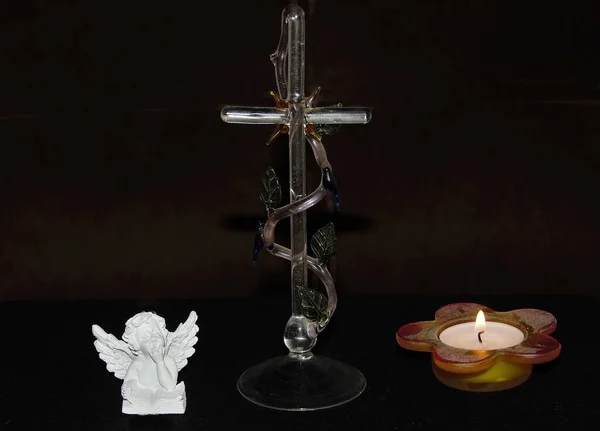 黒を背景に天使のお土産やキャンドルの横にガラスクロスのクローズ — ストック写真