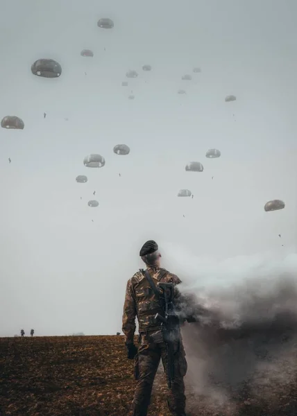 Vertikal Bild Soldat Ett Fält Många Militära Fallskärmshoppare Bakgrund — Stockfoto