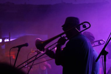 NEW ORLEANS, UNITED STATES - Apr 12, 2019: 12 April 2019 - New Orleans, Louisiana: Jazz musicians performing in the French Quarter of New Orleans, Louisiana, with smoke and neon lights in the b clipart