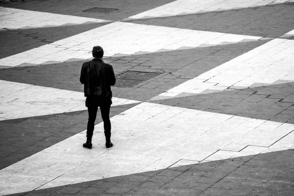 Szare Ujęcie Młodego Mężczyzny Czarnej Skórzanej Kurtce Stojącego Samotnie — Zdjęcie stockowe
