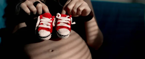 Karnına Yakın Şirin Bebek Ayakkabıları Tutan Hamile Bir Kadın — Stok fotoğraf