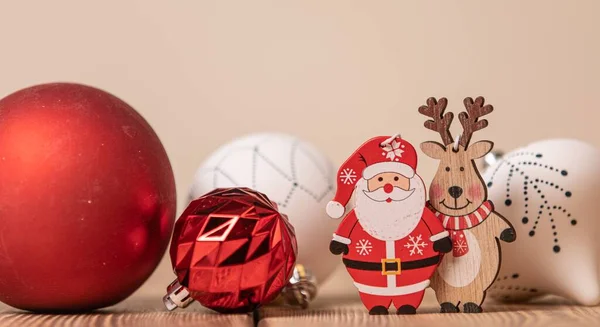 一张特写照片 桌子上摆放着五彩缤纷的圣诞装饰球 上面挂着小木鹿和圣诞老人的雕像 — 图库照片