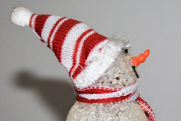 白と赤の色の帽子とスカーフを身に着けているかわいい雪だるまのおもちゃのクローズアップショット ロイヤリティフリーのストック写真