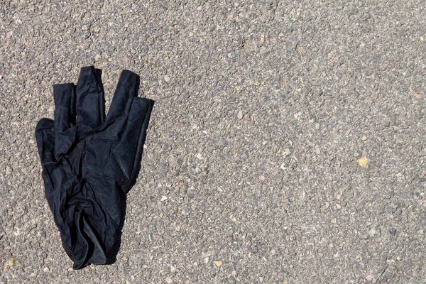 Een Close Shot Van Zwarte Handschoenen Asfalt Achtergrond — Stockfoto