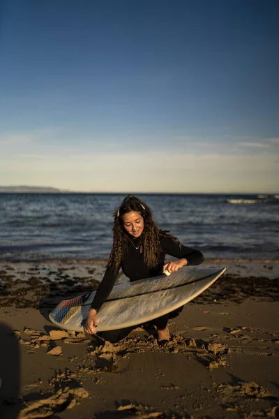 Tiro Vertical Uma Fêmea Sorridente Encerando Sua Prancha Surf Praia — Fotografia de Stock
