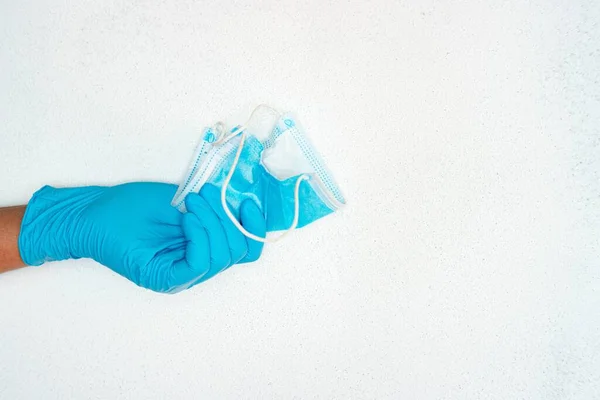 配戴蓝色医疗手套的人手拿着医疗面罩靠近复印室的特写镜头 — 图库照片