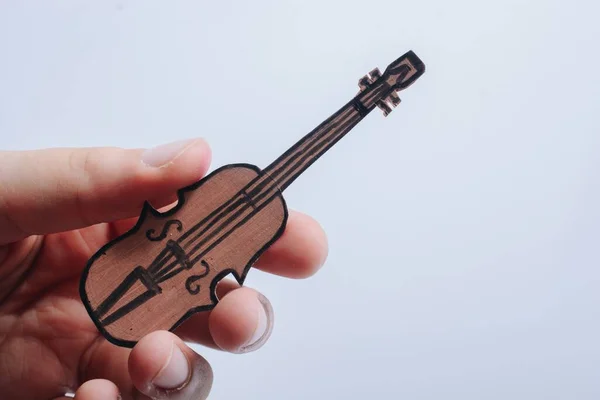 Enfoque Selectivo Una Mano Masculina Sosteniendo Una Guitarra Madera Miniatura — Foto de Stock