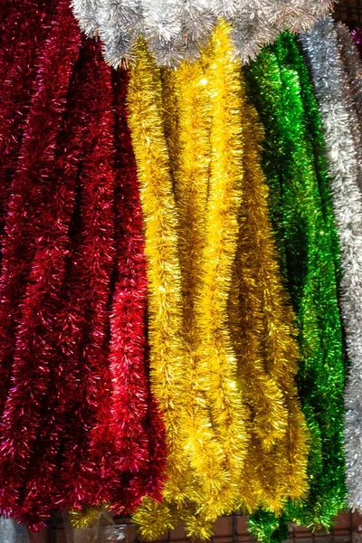 Pionowy Ujęcie Wiszące Kolorowe Błyszczące Girlandy Pod Światłami — Zdjęcie stockowe