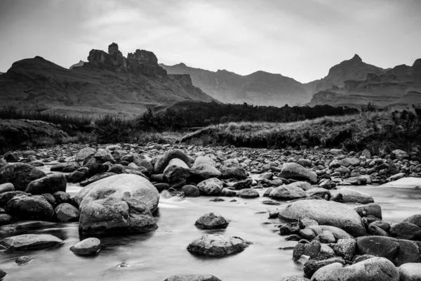 Grayscale Záběr Řeky Vysokými Horami Pozadí — Stock fotografie