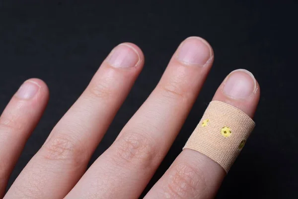 Ett Plåster Persons Finger Svart Bakgrund — Stockfoto