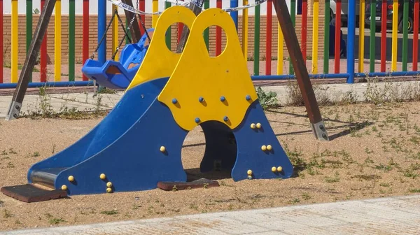 晴れた日に屋外の子供たちの遊び場で黄色の青いスライダー — ストック写真