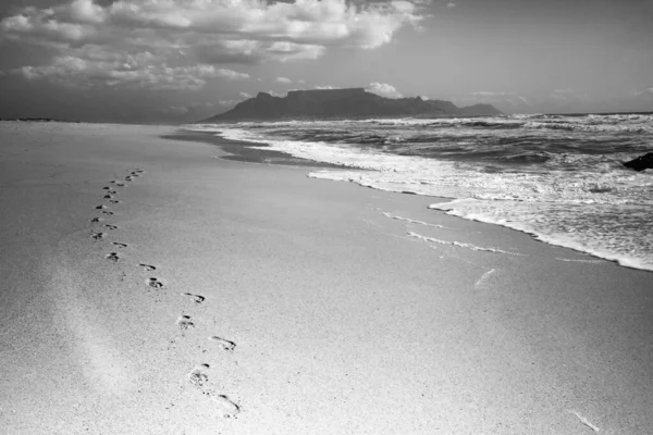 Greyscale Shot Footprints Beach Beautiful Ocean Cloudy Sky — Stock Photo, Image