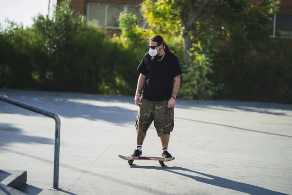 Mladý Muž Dělá Různé Triky Skateboardem Parku Maskou Lékařské Tváře — Stock fotografie