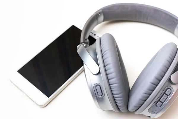 Closeup Shot Gray Headphone Next White Modern Smartphone Isolated White — Stock Photo, Image