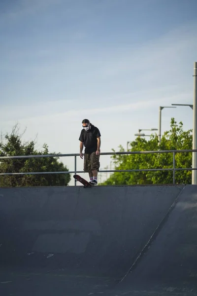 Ένας Νεαρός Άνδρας Που Περπατά Ένα Πάρκο Ένα Skateboard Φορώντας — Φωτογραφία Αρχείου