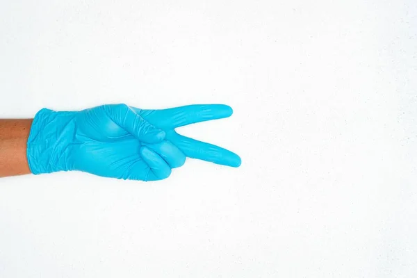 一个戴着蓝色医疗手套的人的特写照片 照片上的人在复印室附近手拉手示牌 — 图库照片