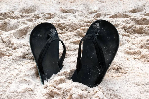 沙地上的黑色凉鞋特写 — 图库照片