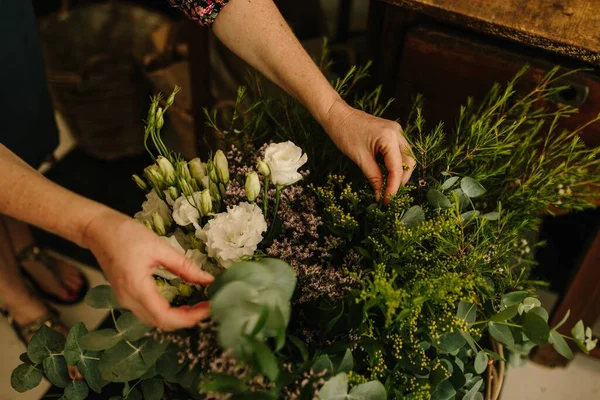 花のデザインスタジオで花の手配をするヨーロッパの女性花屋 — ストック写真
