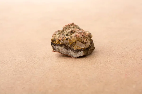 滑らかなピンクの背景に孤立した火成岩の小片のクローズアップショット — ストック写真