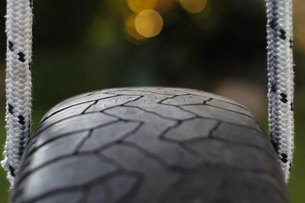 ぼやけた背景にタイヤのスイングのクローズアップショット — ストック写真