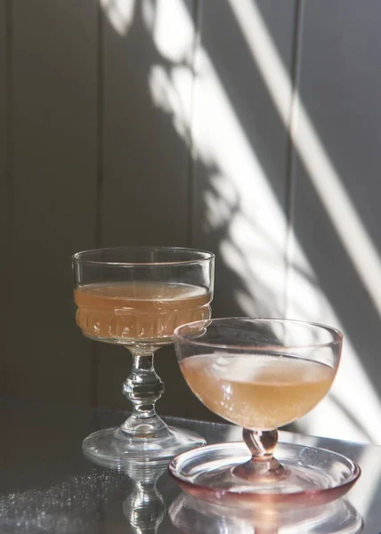 Eine Vertikale Nahaufnahme Von Zwei Gläsern Saft Sonnenstrahlen Und Schatten — Stockfoto