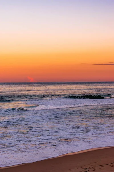 日没時に海岸に転がり込む穏やかな波 — ストック写真