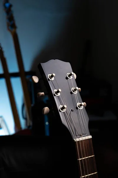 Tiro Vertical Uma Guitarra Uma Parede Azul Com Sombras — Fotografia de Stock