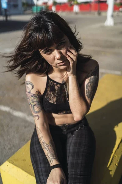 Μια Νεαρή Ελκυστική Καυκάσια Γυναίκα Τατουάζ Κάθεται Στο Δρόμο — Φωτογραφία Αρχείου